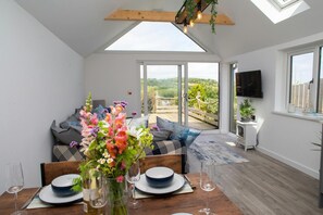View from the dining/living are through patio doors to the deck area and garden