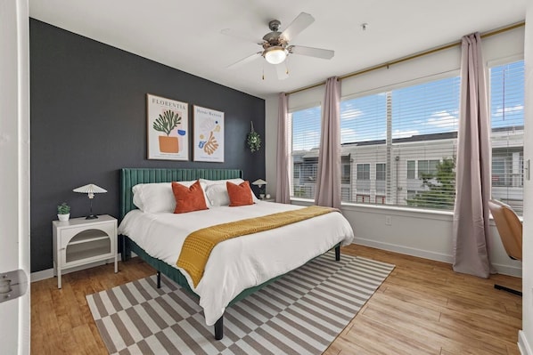 Rest easy in the master bedroom featuring a plush king-sized bed, vibrant decor, and ample natural light. The modern design and cozy ambiance create the perfect retreat for a peaceful night's sleep. Enjoy the comfort and tranquility of this inviting space