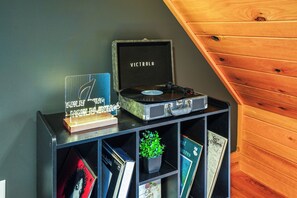 Groove to the beats with our themed media room featuring a record player, ambient lighting, and a curated vinyl collection for a retro-chic experience. 🎶✨ #VinylVibes