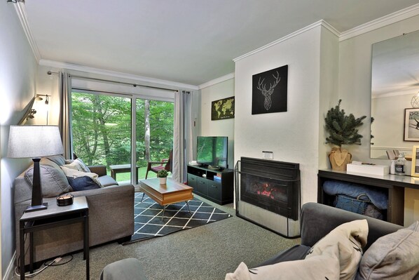 Enjoy the living area with its gas fireplace and RokuTV for cozy nights in. Additional sleeping space includes a full-size pull-out couch and a twin pull-out loveseat. The patio offers a serene view of the woods and golf course.