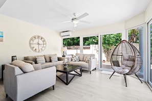 Relax in a spacious living area with plush seating and a welcoming atmosphere of the home in Noord Aruba - Sliding glass doors to the backyard with pool and plenty of combatable loungers - Perfect blend of comfort and style, ideal for unwinding