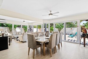 Gather around the elegant dining table, perfect for sharing meals and making memories - Dine in style in a spacious area designed for 8 persons - Enjoy meals in a bright and airy atmosphere with panoramic windows and pool views