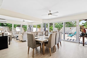 Gather around the elegant dining table, perfect for sharing meals and making memories - Dine in style in a spacious area designed for 8 persons - Enjoy meals in a bright and airy atmosphere with panoramic windows and pool views
