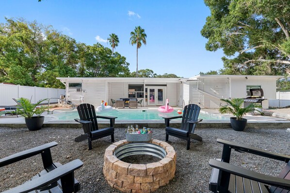 The fire pit, built with a rustic yet elegant design, serves as a natural gathering spot where family and friends can come together.