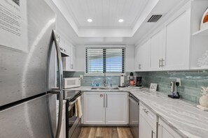 The beautifully updated kitchen, complete with granite countertops, stainless steel appliances, and essential cooking tools—including a standard and Keurig coffee maker, toaster, and microwave—ensures you have everything you need.