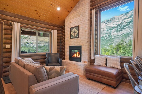 Make your cabin living room the perfect retreat with a smart TV for streaming, a cozy couch, and a inviting fireplace