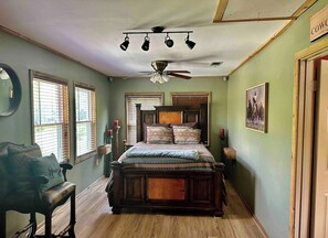 Bedroom adorned with chandelier fan and scenic window