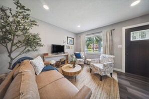 Serene living area with windows overlooking beautiful neighborhood