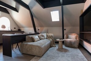 Living room with comfortable sofa and lounge chair, and cable TV
