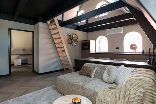 Living room and kitchen with stairs to second bedroom