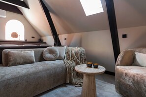 Living room sofa with small TV table and window