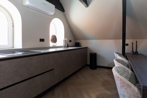 Kitchen area with sink and induction cooking plate, air-conditioning unit, dining area