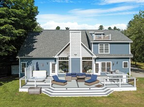 Spacious back deck with plenty of seating, a hot tub, and direct access to the yard—ideal for relaxing or entertaining in a peaceful setting.