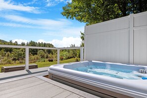 Unwind in the private outdoor hot tub with breathtaking views of the surrounding greenery and mountains. Perfect for relaxing after a day of exploring or simply enjoying a peaceful, serene moment in nature.