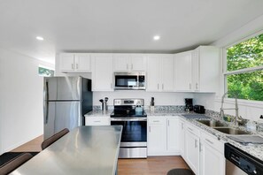 Enjoy cooking in our newly equipped kitchen with stainless appliances and ample natural light (Unit #1)