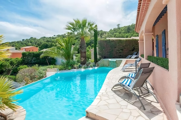 Enjoy a refreshing dip in the private pool, surrounded by lush greenery and the villa's charming stone patio. Relax on one of the lounge chairs and soak in the stunning view of the surrounding hills and the Mediterranean Sea in the distance. The pool can
