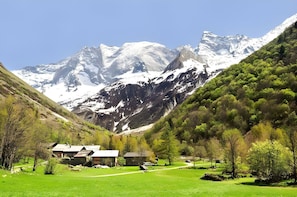 This panoramic view showcases the stunning natural beauty surrounding Casa-Chalet le Pointon N° 2 in Champagny-en-Vanoise. The chalet is nestled amidst a picturesque valley, with snow-capped mountains rising majestically in the background. Lush green tree