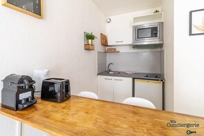 Coin repas et kitchenette équipée avec bouilloire, grille pain, micro onde et...