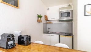 Coin repas et kitchenette équipée avec bouilloire, grille pain, micro onde et...