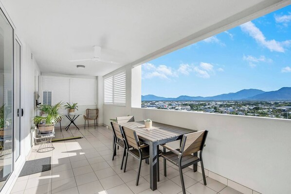 Head outside to enjoy the first apartment's spacious balcony, set for alfresco dining at sunset.