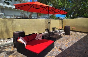 Backyard with daybed , large umbrella for shade and seating