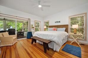 A primary suite fit for a king, this bedroom opens up to a private screened-in porch. 