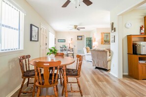 Bright and cozy living space with a classic wooden dining set and open layout for relaxation and comfort.