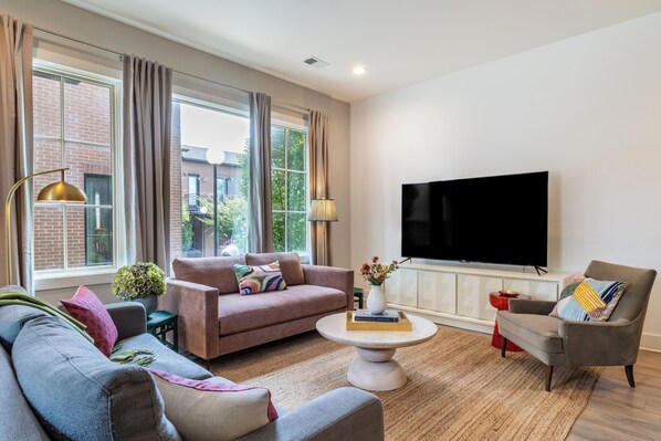 The living room features a flat-screen TV and a sleeper sofa for added sleeping options.