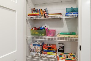 Stocked game closet with board games, books, and toys, perfect for family fun and entertainment during your stay.