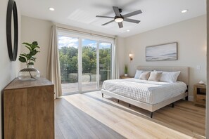 Spacious and serene bedroom with a king-sized bed, large windows, and private deck access.