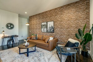 Unit 1: Bright and open living area with designer furnishings and smart TV.