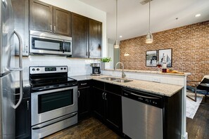 Unit 1: Fully equipped kitchen stocked with basic cooking essentials and complete with bar seating.