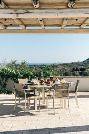 Pergola-covered breakfast area, offering a beautiful view of the sea.