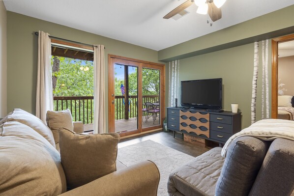 Cozy living area with ceiling fan, cable TV & deck access