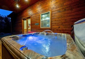 Unwind in the private hot tub after a day of adventure, surrounded by the serene beauty of nature.