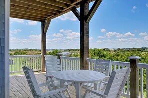 Covered deck with cozy dining and stunning water views for a peaceful retreat.