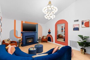 Lounge in style with colorful decor, a cozy fireplace, and a plush sectional—perfect for movie nights or group hangouts!