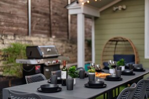 Gather, grill, and dine under the lights in this cozy backyard setup — perfect for memorable evenings!