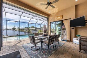 Large outdoor living space with sparkling, private pool & spa overlooking the water. Outdoor living space also includes a dining table for 6, sun loungers, outdoor seating, BBQ grill, and two 55-inch Smart TVs