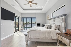 Primary bedroom with king bed, en suite, lanai access, and 65-inch Smart TV