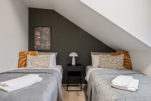 Experience unrivaled comfort in the second bedroom, furnished with two snug 90cm beds, each boasting a premium mattress and crisp linens for a touch of luxury. Enjoy uninterrupted sleep with the inclusion of blackout shades.