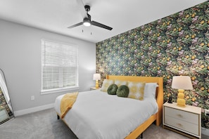 This is a bright and modern bedroom with a bold accent wall