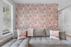 This picture shows a cozy and stylish living room area, featuring a prominent accent wall and comfortable seating