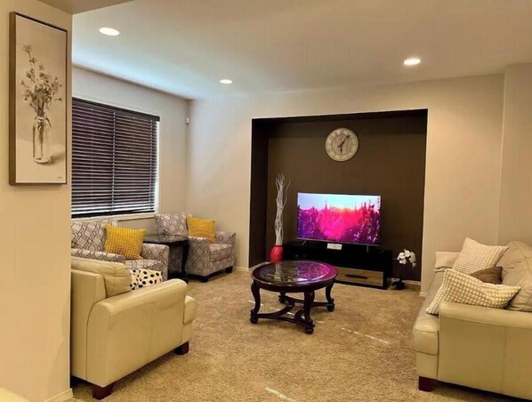 Spacious and well-lit living room with beautiful venetian blinds.