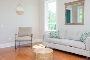 Living room with bright sun light and 2 sling chairs and a  smart TV.