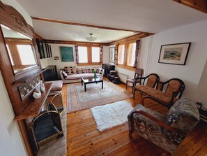 Cozy sitting area with vintage fireplace, wooden floors, lots of natural light