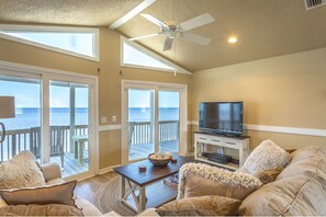 Living room has gorgeous ocean views, deck access & large smart TV
