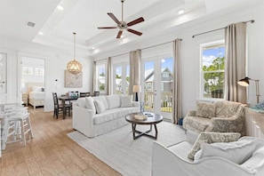 Unwind in this bright and spacious living area, featuring plush seating, large windows, and an open-concept design that brings in plenty of natural light.