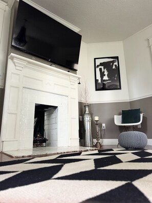 Stylish living room with bold modern decor, smart TV & cozy vintage charm