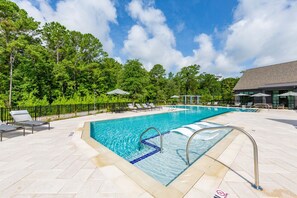 The main focus is a large, rectangular swimming pool with clear blue water